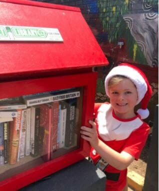 a child wearing a santa hat and a Street Library