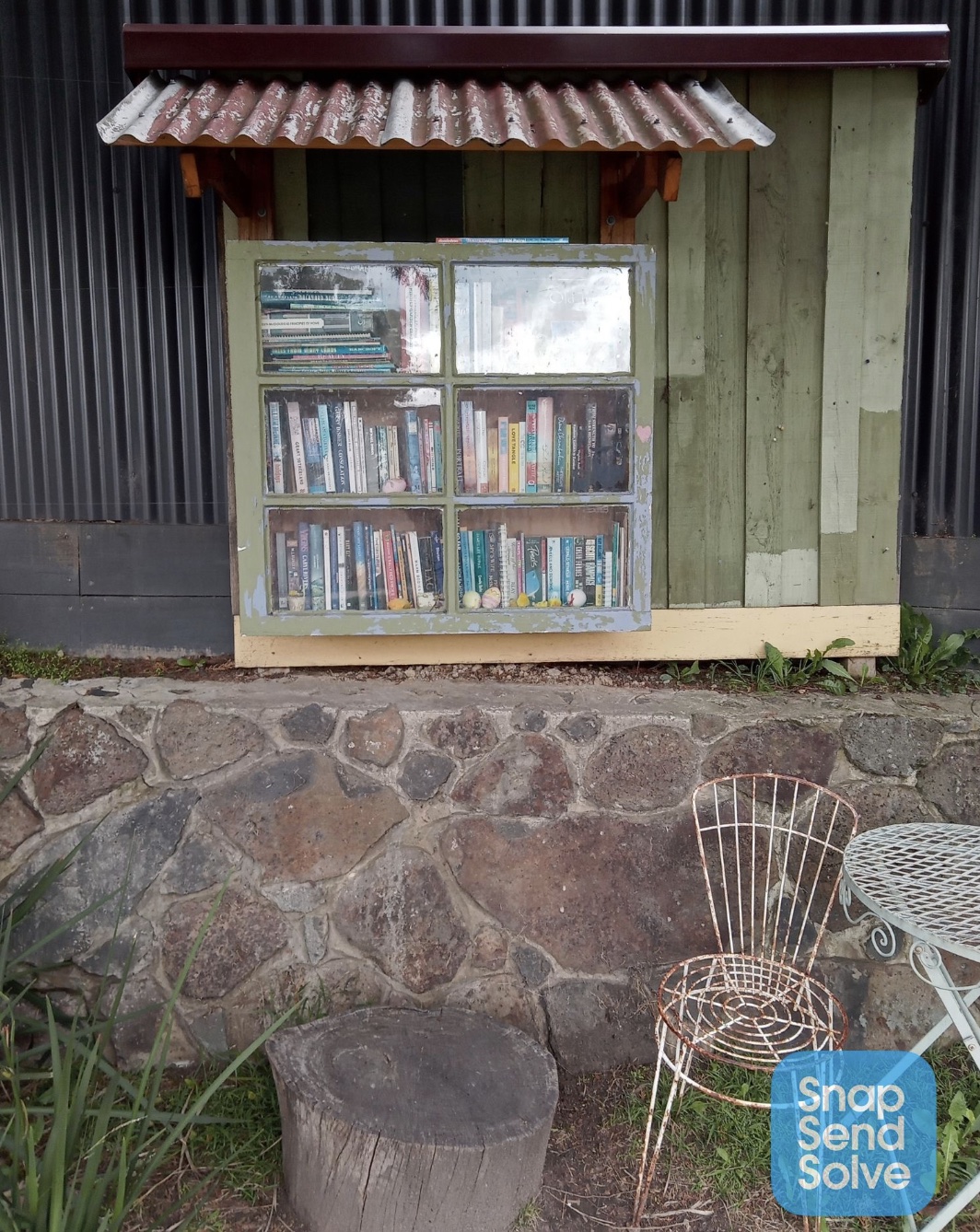 A Street Library covered by a garbage bag to protect it from the weather