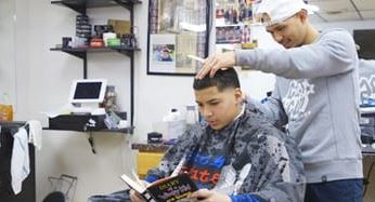 Barber pays kids to read a book during haircut to boost literacy, confidence