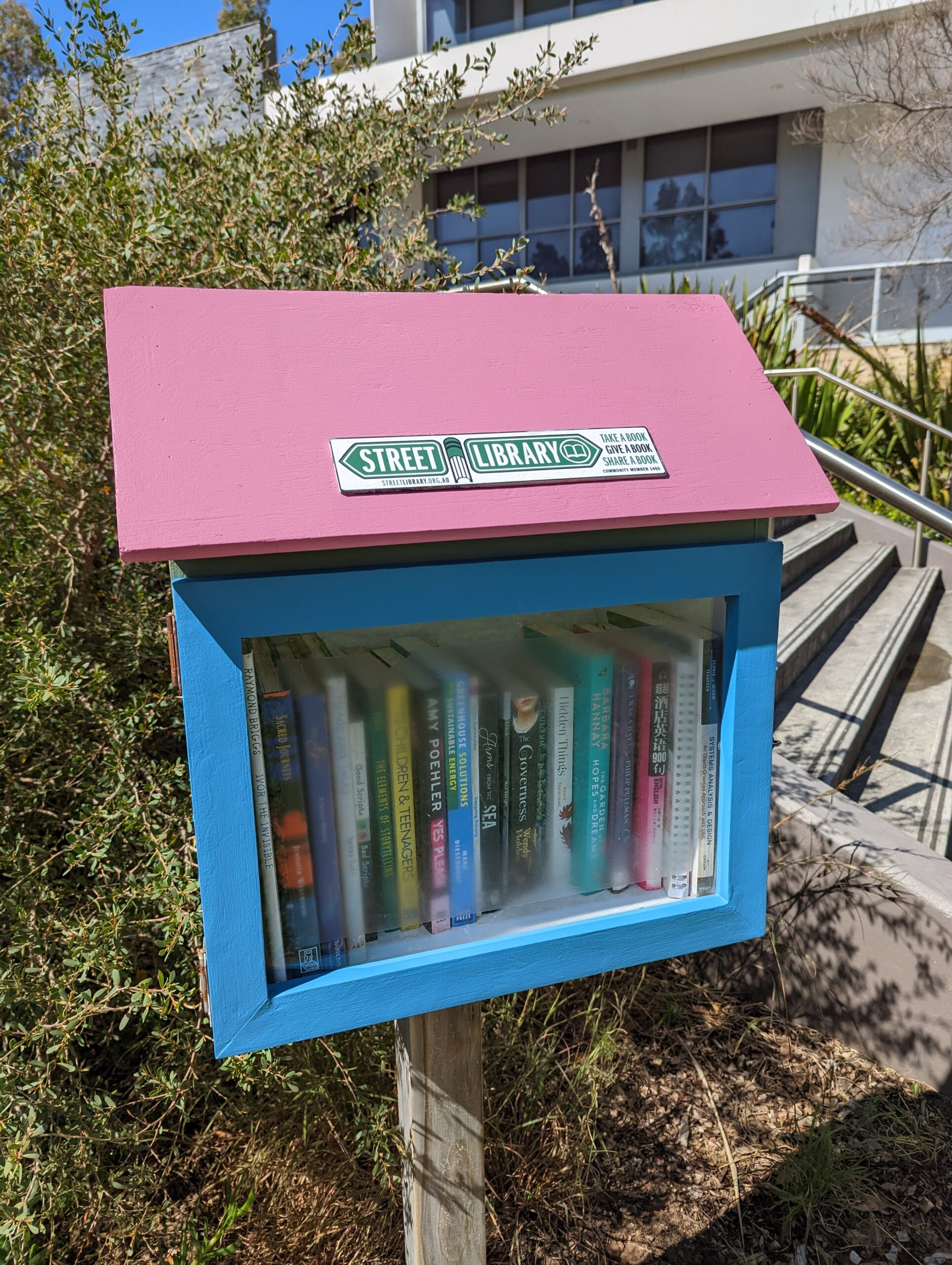 A Street Library with a pink roof and blue body.