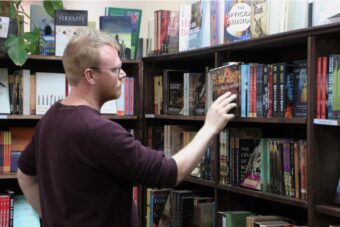Picture of Toby Wools-Cobb of Quixotic Books browsing in his store
