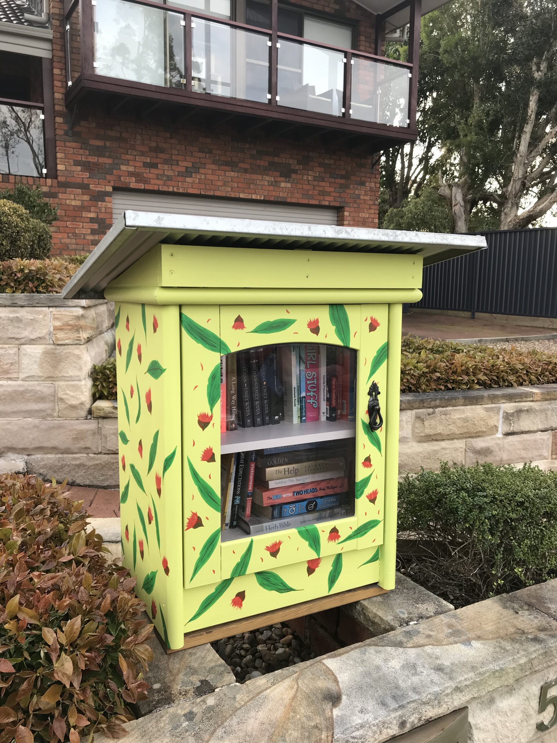 A home-made Street Library with a handy eave to protect against the weather