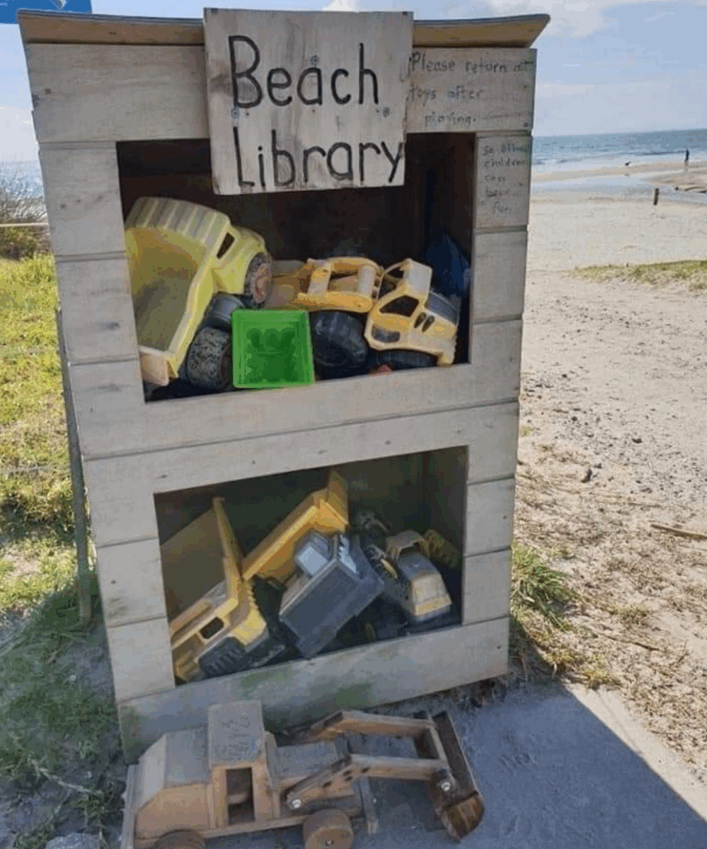 A wooden structure at a beach, holding toys for sharing and borrowing.