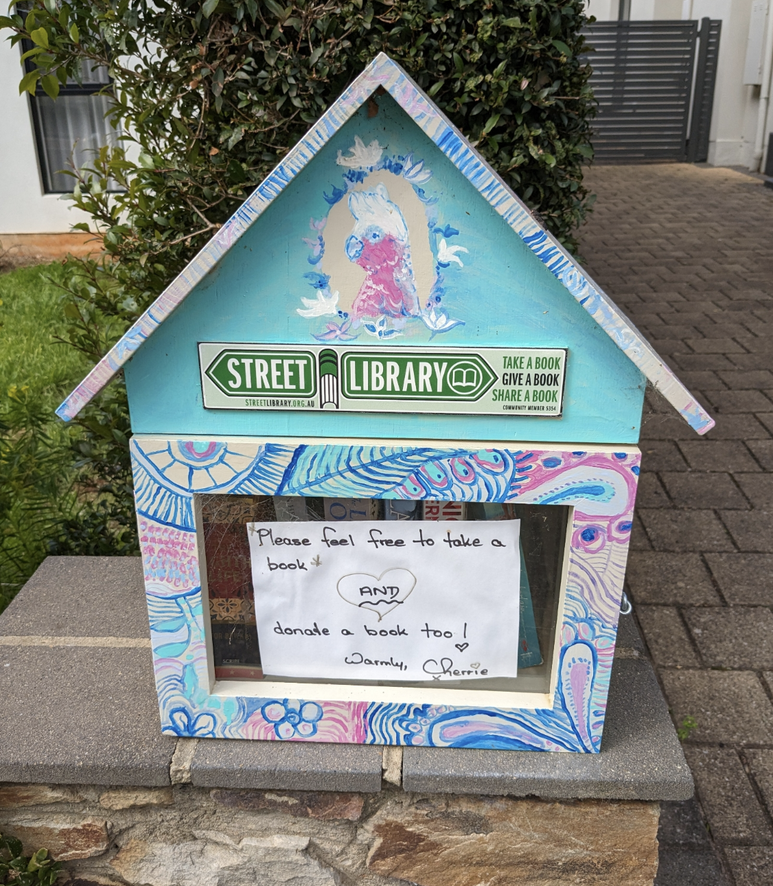 A beautifully painted Street Library on Wooltana Avenue in Myrtle Bank, SA. There is a galah painted on the front!